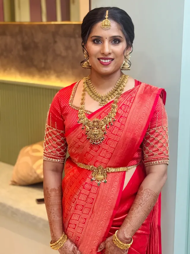 Kerala bride in a red silk saree with temple jewellery and detailed mehendi