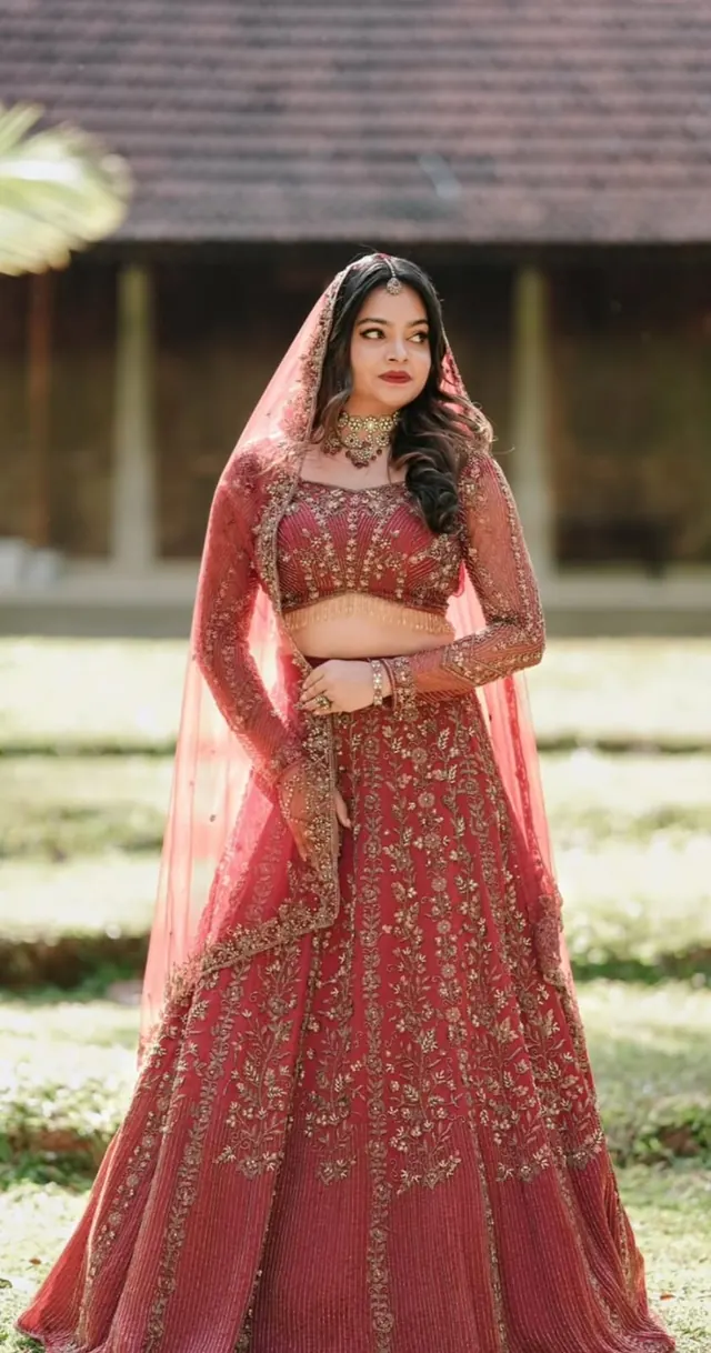 Wedding-day bride in a deep red embroidered lehenga, full bridal look