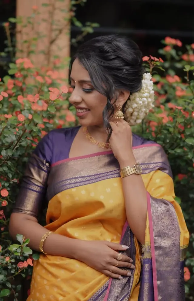 Bridal updo hairstyle with jasmine flowers and yellow silk saree