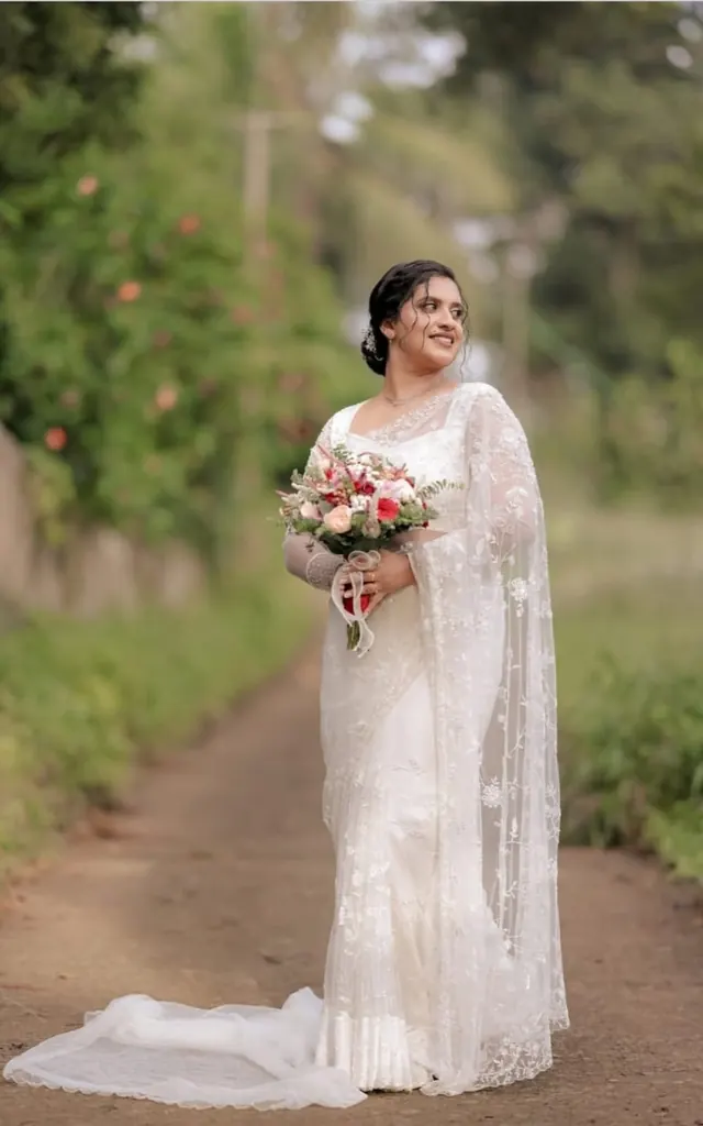 Christian bride in white lace saree with bridal bouquet
